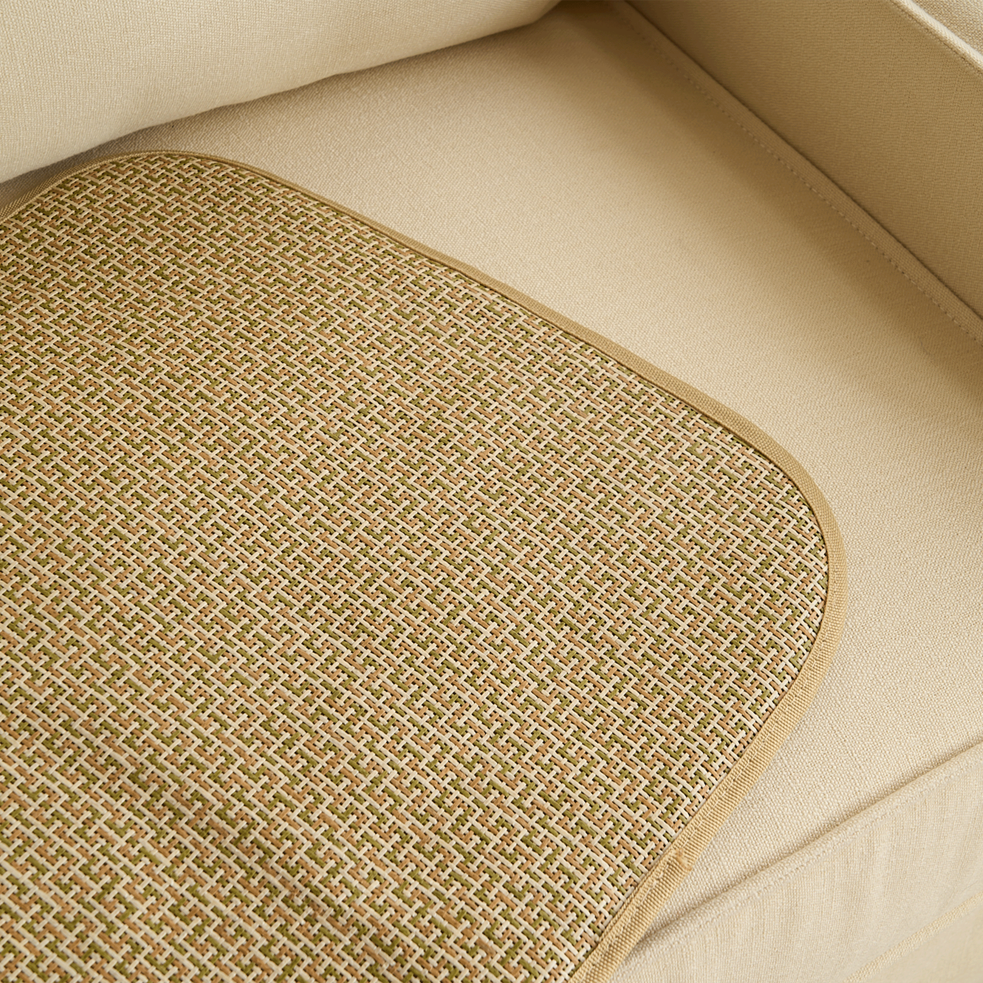 Geflochtene Rattan-Kühlmatte für Haustiere, beige, auf beigem Sofa, langlebig, atmungsaktiv.