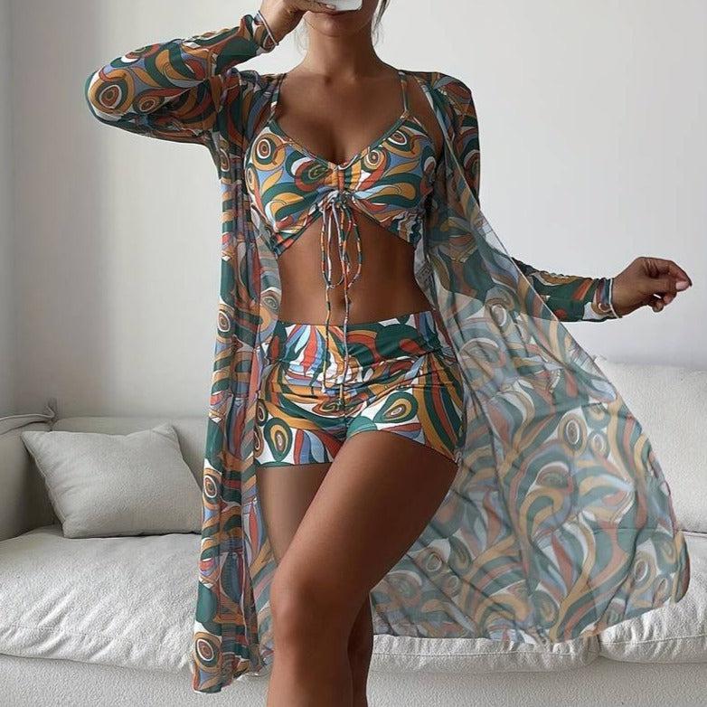 Frau in buntem, gemustertem Strandoutfit mit Kimono, Top und Shorts. Sommermode, Strandkleidung, Boho-Stil, trendige Damenbekleidung.