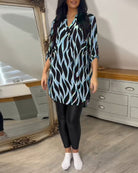 Elegantes Damen-Outfit mit gemusterter Tunika und schwarzen Leggings, ideal für modische Freizeitlooks. Perfekt für stilvolle Alltagsmode.