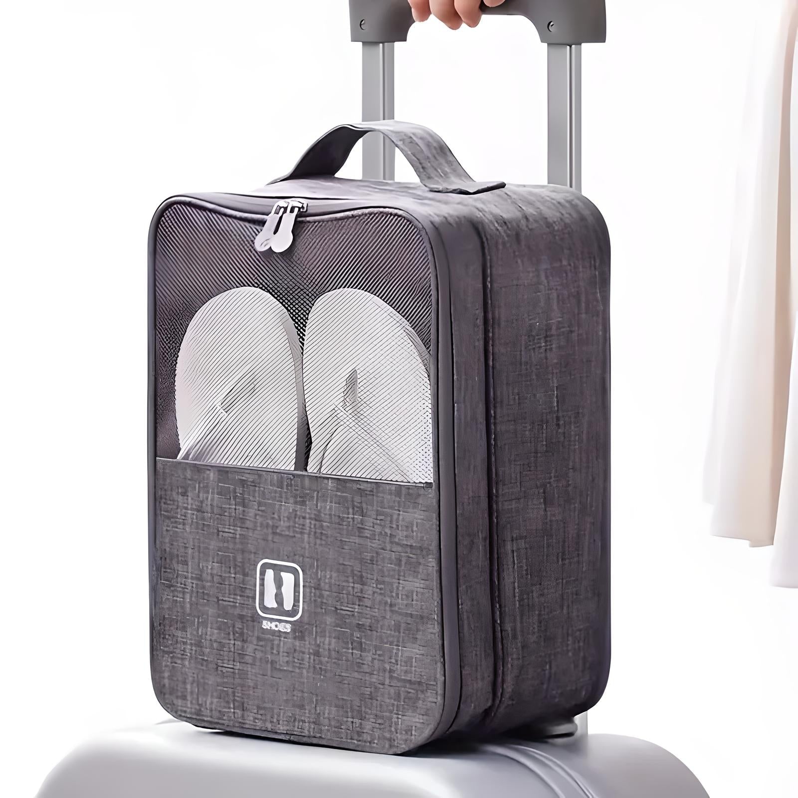 Grauer Schuhbeutel mit Reißverschluss, Netzfach und Tragegriff auf Koffer, ideal für Reisen.