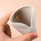 Weiße Silikon-Menstruationstasse, flexibel, in Hand gehalten, umweltfreundlich, wiederverwendbar.