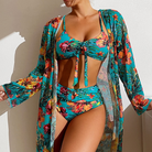 Frau in floralem Bikini-Set mit hoher Taille und Mesh-Bluse, tropisches Design, Bademode.
