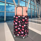 Rosa Reisetasche und schwarzer Koffer mit Herzmuster im modernen Flughafen-Terminal.