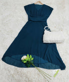Elegantes blaues Abendkleid aus Chiffon mit V-Ausschnitt, kombiniert mit weißer Handtasche und Rose. Perfekt für festliche Anlässe.