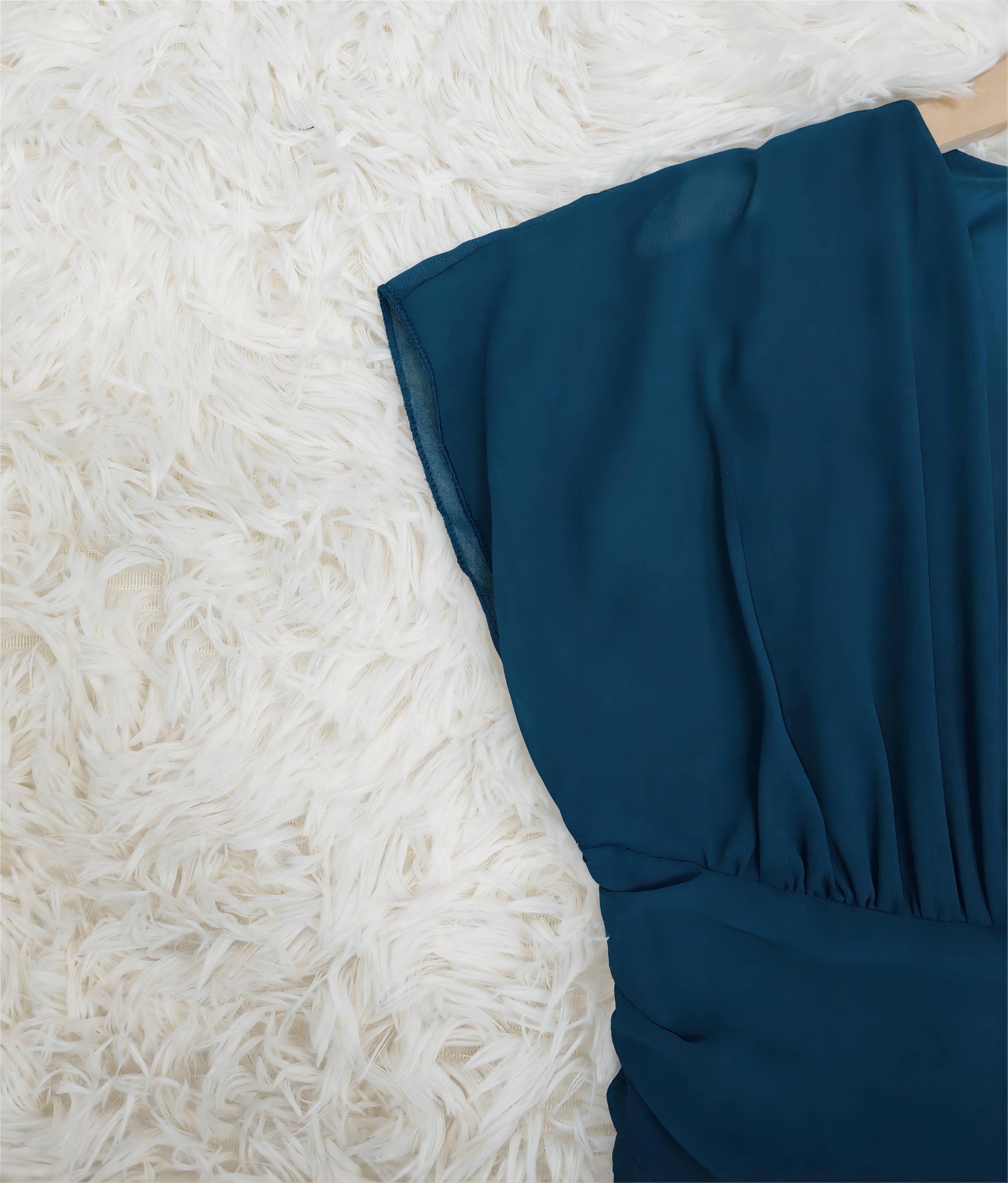 Elegantes blaues Kleid auf weißem, flauschigem Teppich. Perfekt für Abendmode, Damenbekleidung, stilvolle Outfits und modische Anlässe.