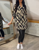 Damenmode: Langes, gemustertes Hemdkleid in Schwarz-Weiß, kombiniert mit schwarzen Leggings. Stilvoller Look für Freizeit und Alltag.