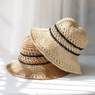Zwei gehäkelte Damenstrohhüte mit UV-Schutz, gestreiftem Design und Fischerhut-Stil. Perfekt für Sommermode und Sonnenschutz.