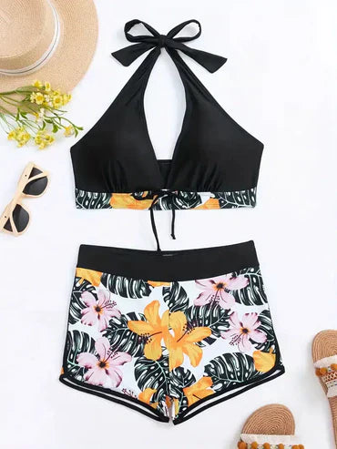 Damen-Bikini-Set mit tropischem Blumenmuster, schwarzem Neckholder-Oberteil und Shorts. Perfekt für Strandmode und Sommerurlaub.