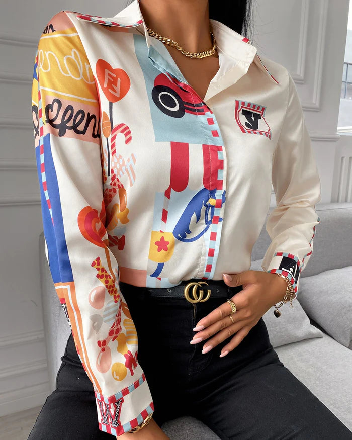 Elegante Damenbluse mit buntem, grafischem Print, kombiniert mit schwarzer Hose. Perfekt für modische Outfits und stilvolle Anlässe.