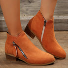 Damen Stiefeletten in Orange mit seitlichem Reißverschluss, flachem Absatz und Wildlederoptik. Perfekt für Herbstmode und lässige Outfits.