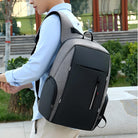 Mann mit grauem, modernem Laptop-Rucksack im Freien, ergonomisches Design, stilvoll und funktional.