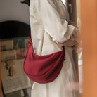 Frau mit roter Umhängetasche aus Stoff, lässiger Stil, modisches Accessoire, Innenaufnahme.