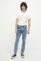 Mann in weißem T-Shirt und blauer Jeans, lässiger Look, Modefotografie, Vintage-Stil.