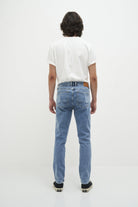 Mann in blauer Vintage-Jeans und weißem T-Shirt, Rückansicht, lässige Mode.