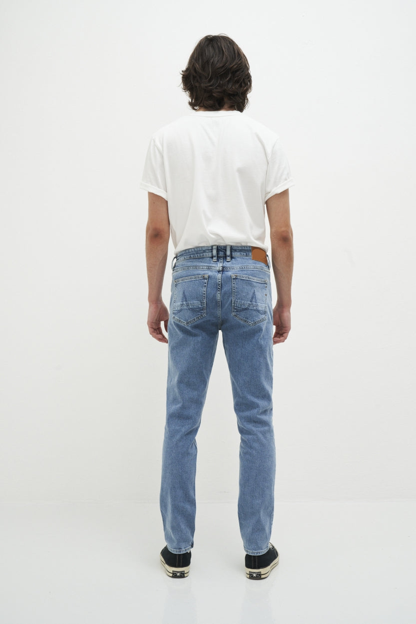 Mann in blauer Vintage-Jeans und weißem T-Shirt, Rückansicht, lässige Mode.