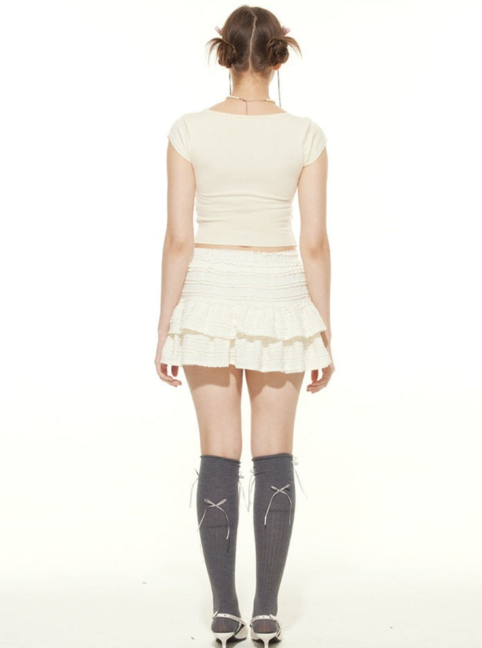 Frau in weißem Top und Rock, graue Kniestrümpfe, Rückansicht. Modetrend, Sommeroutfit, Damenbekleidung, stilvoll, lässig, modern.