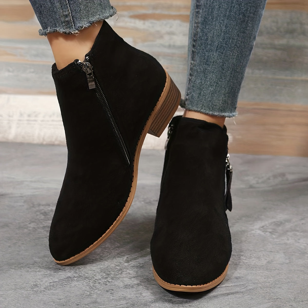 Schwarze Damen-Stiefeletten mit Reißverschluss, flachem Absatz und runder Spitze. Perfekt für Herbstmode, bequem und stilvoll.