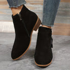Schwarze Damen-Stiefeletten mit Reißverschluss, flachem Absatz und runder Spitze. Perfekt für Herbstmode, bequem und stilvoll.