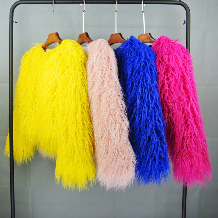 Bunte Kunstpelzmäntel auf Kleiderstange: Gelb, Rosa, Blau, Pink. Modetrend, auffällige Farben, stilvolle Winterbekleidung, Damenmode.