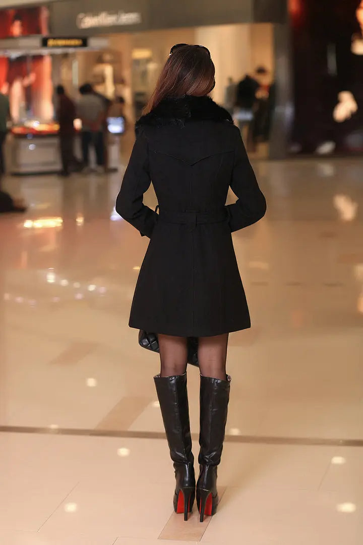 Eleganter schwarzer Mantel für Damen, kombiniert mit stilvollen, kniehohen Stiefeln. Perfekt für modische Herbst- und Winteroutfits.
