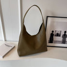 Olivegrüne Handtasche aus Leder mit gewebtem Muster, elegant und stilvoll, ideal für den Alltag. Perfekt als modisches Accessoire.