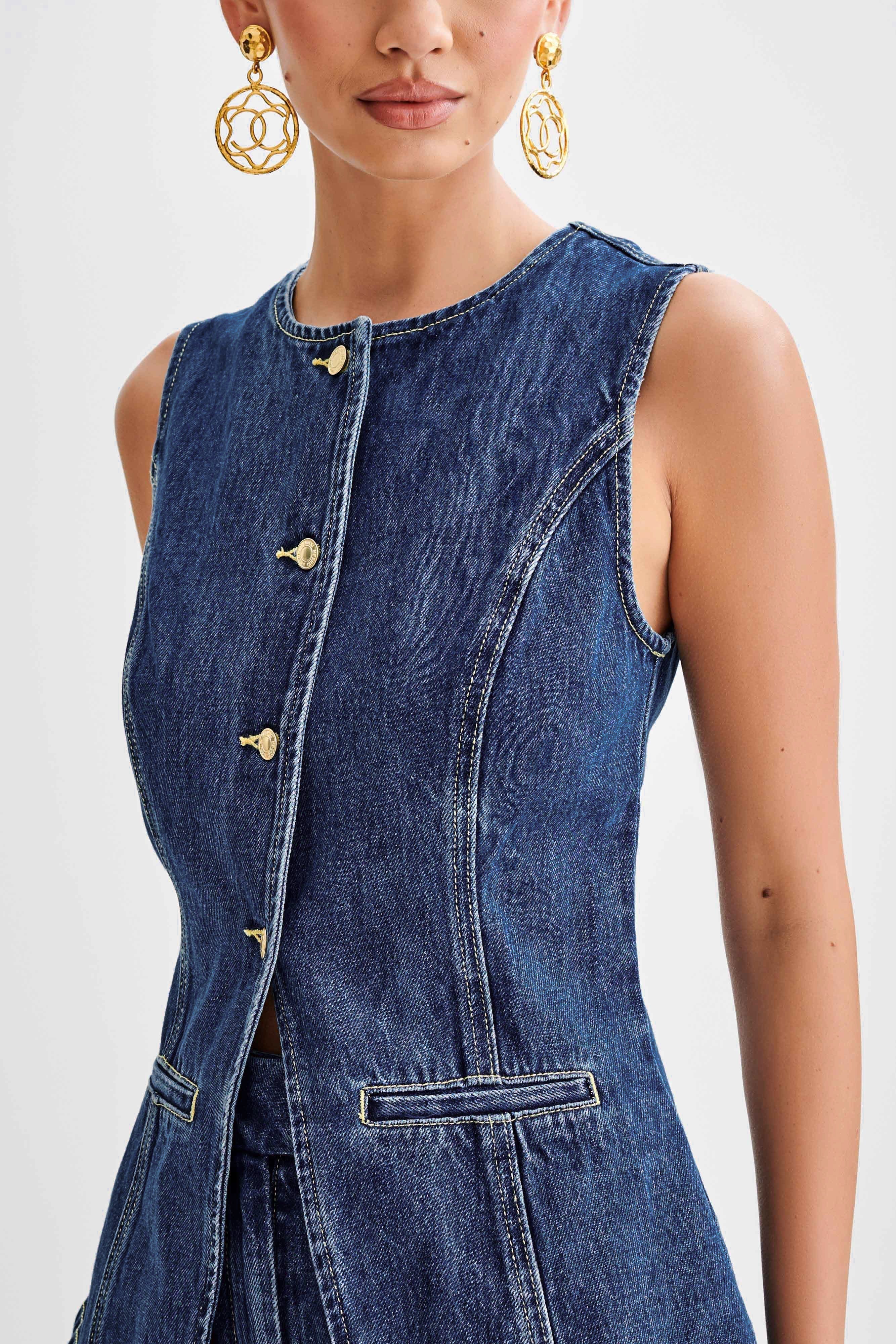 Ärmellose Jeansweste mit goldenen Knöpfen und eleganten Nähten, kombiniert mit auffälligen, goldenen Ohrringen. Perfekt für modische Outfits.