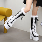 Schwarze Plateau-Stiefel mit weißem Kunstfell und Schnürung, modisch und trendig, ideal für Wintermode und auffällige Outfits.