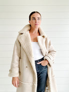 Damen Wintermantel aus beigem Kunstfell, warm gefüttert, modisch und elegant, ideal für kalte Tage. Perfekt für stilvolle Winteroutfits.