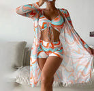 Frau in buntem, gemustertem Strandoutfit mit Kimono, Top und Shorts. Sommermode, Strandkleidung, trendige Bademode, lebendige Farben.