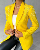 Eleganter gelber Blazer mit Perlenverzierung, kombiniert mit weißem Top und schwarzer Lederhose. Perfekt für modische, stilvolle Outfits.