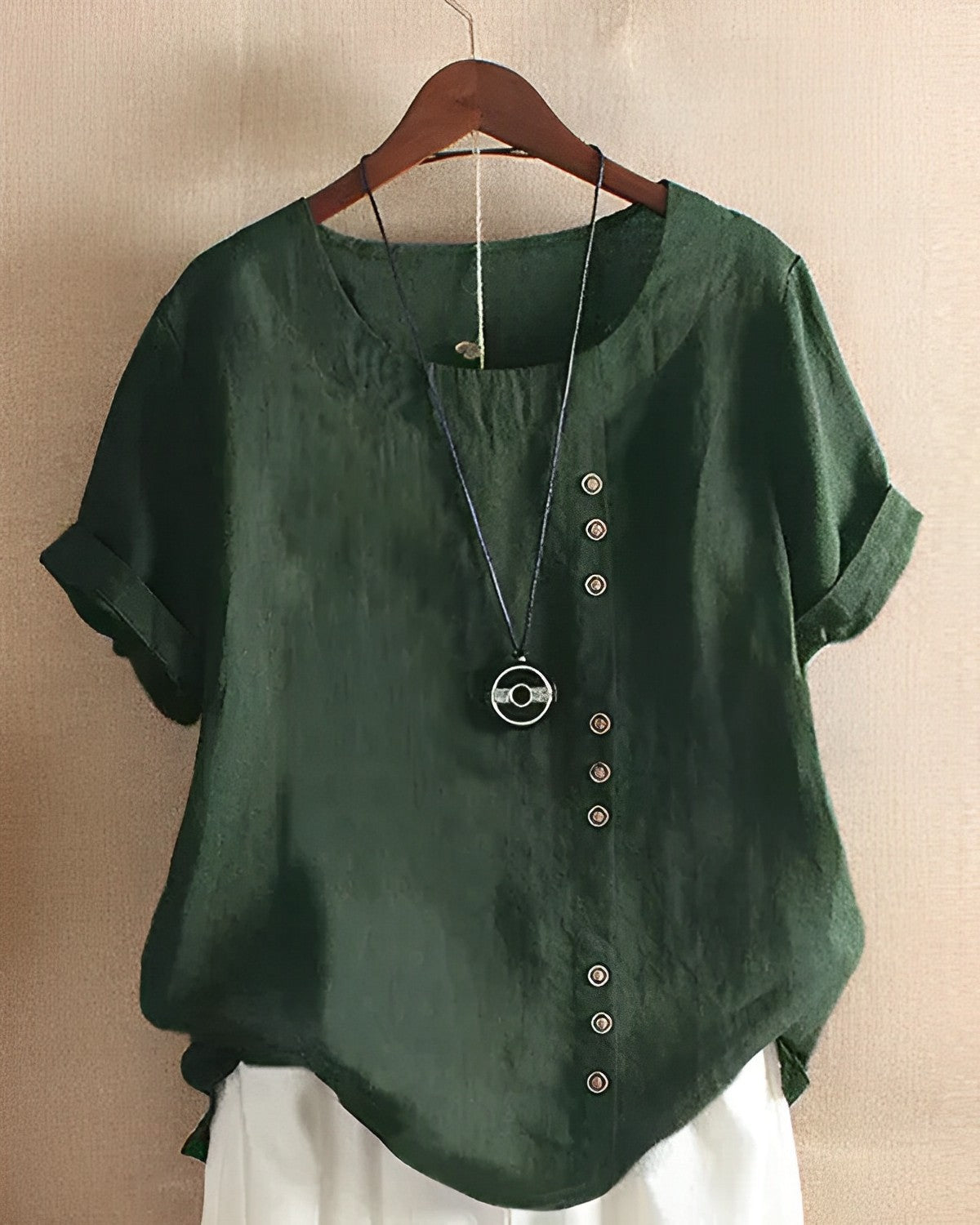 Dunkelgrüne Leinenbluse mit Knopfleiste, lässiger Stil, Damenmode, hängend auf Holzkleiderbügel.
