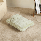 Grünes, flauschiges Kissen auf Teppichboden, beruhigend, dekorativ, Wohnzimmer.