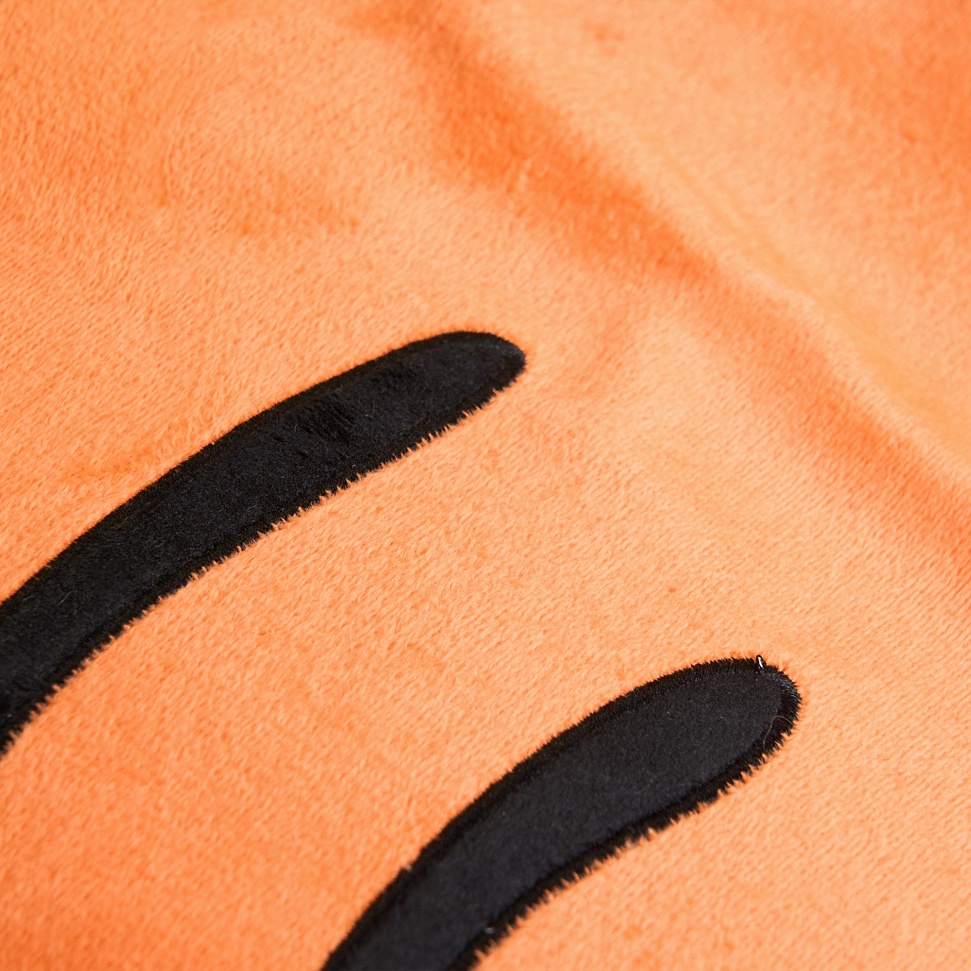 Orangefarbenes Plüsch-Haustierbett mit schwarzen Streifen, weiches Material, gemütlich.