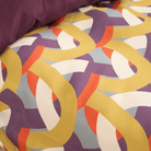 Buntes Hundebett mit geometrischem Muster, lila, gelb, rot, aus Stoff, modernes Design.