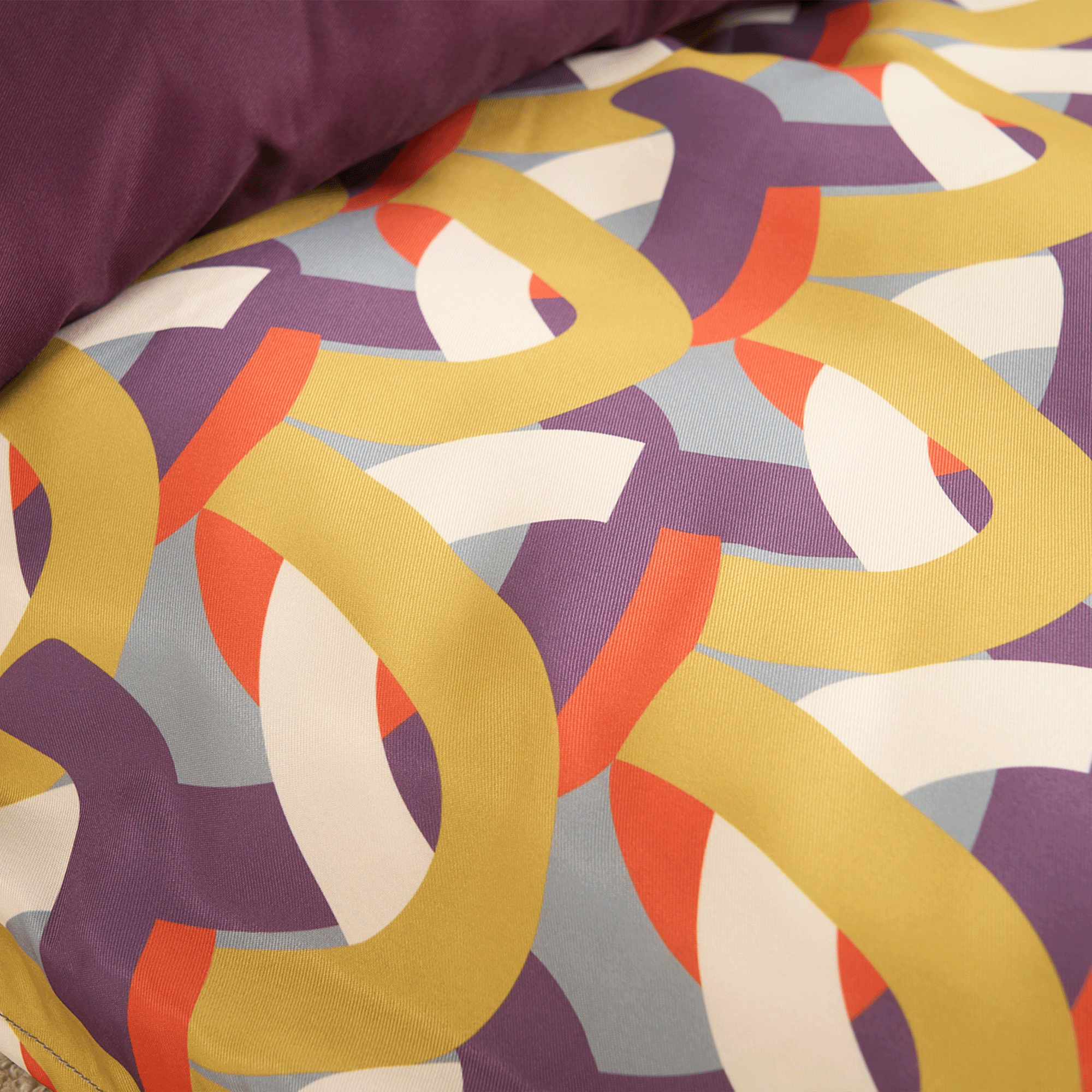 Buntes Hundebett mit geometrischem Muster, lila, gelb, rot, aus Stoff, modernes Design.
