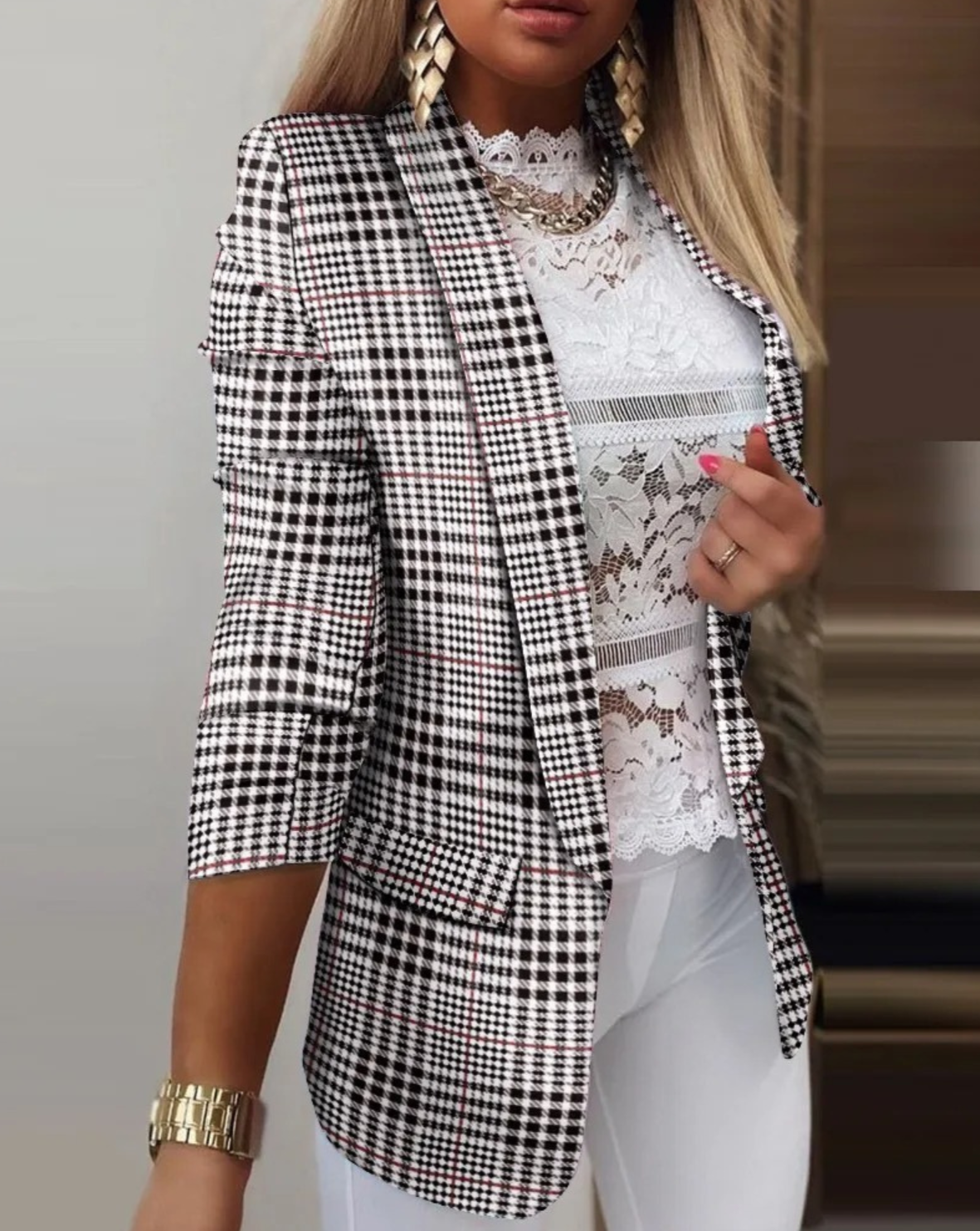 Damen-Blazer mit Hahnentrittmuster, kombiniert mit weißer Spitzenbluse und goldenen Accessoires. Eleganter Business-Look für stilvolle Frauen.