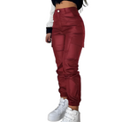 Damenhose in Rot, hoch tailliert, mit Seitentaschen. Modische Streetwear, ideal für trendige Outfits. Perfekt kombiniert mit weißen Sneakers.