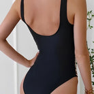 Frau in schwarzem Badeanzug, Rückenansicht, elegantes Design, Sommermode, Bademode Damen.
