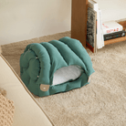 Grünes Katzenbett aus Stoff, gemütlich, auf Teppich, modernes Design, ideal für Haustiere.