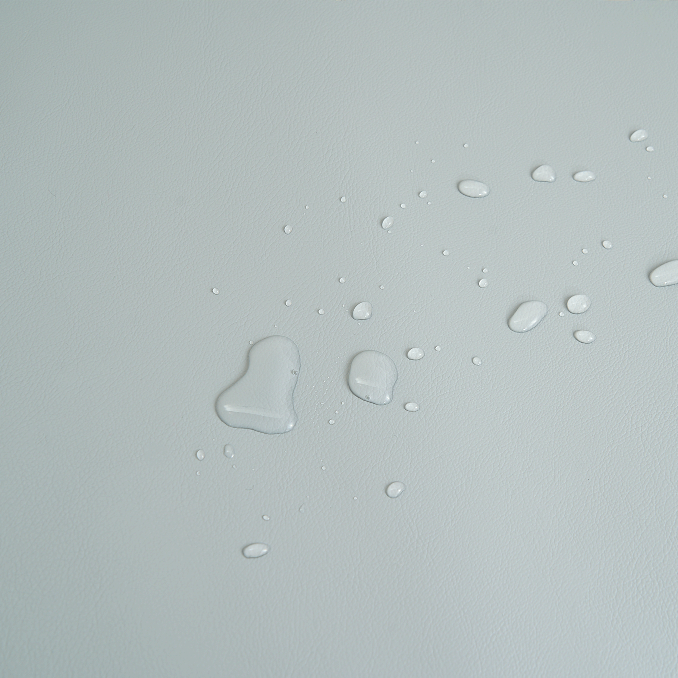 Wasserabweisende Oberfläche mit Wassertropfen, hellgrau, strapazierfähiges Material.