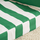 Grün-weiß gestreiftes Haustiersofa auf Teppich, modernes Design, bequeme Tiermöbel.