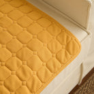 Gelbe Waffelstruktur-Absorptionsmatte auf beigem Sofa, Haustierunterlage, waschbar.