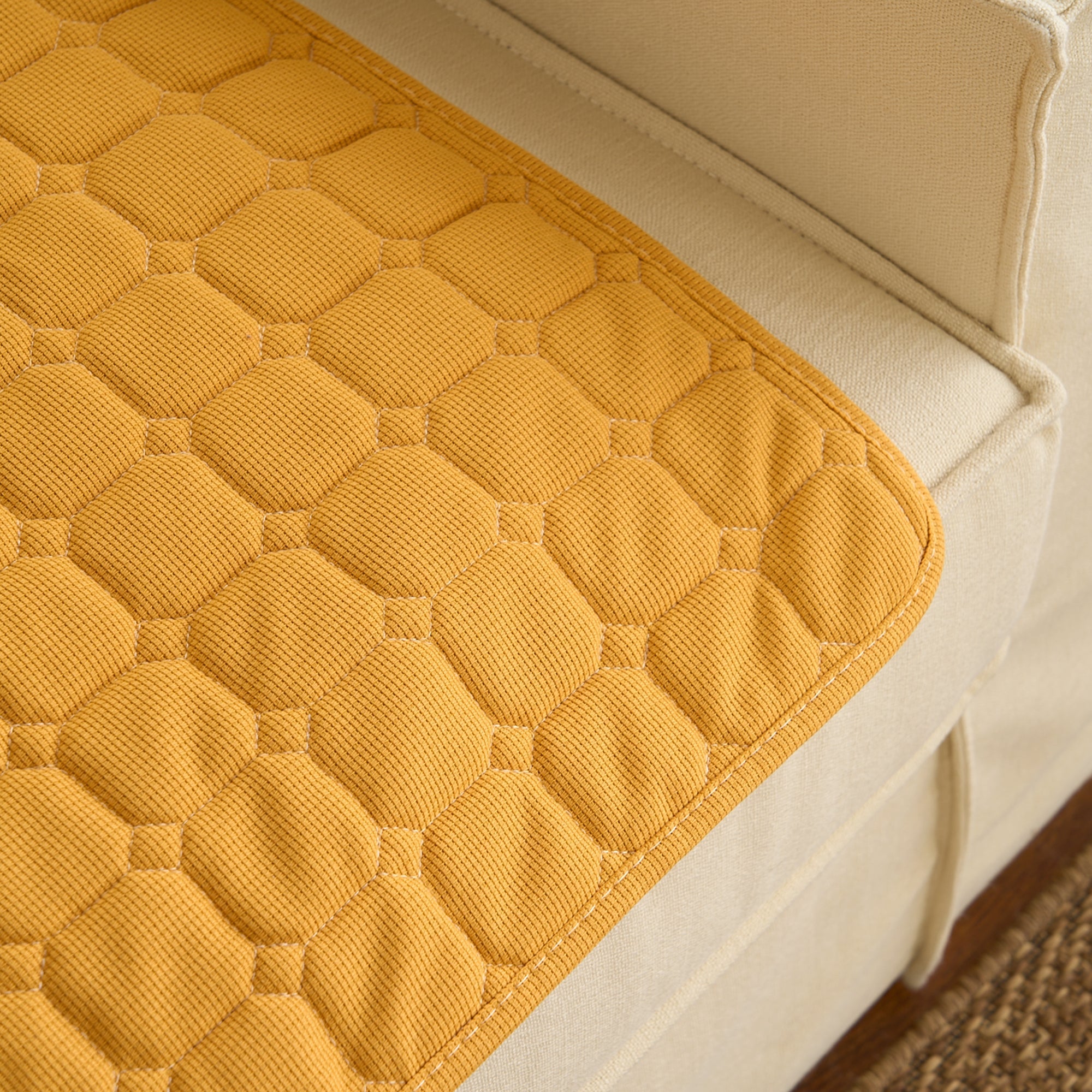 Gelbe Waffelstruktur-Absorptionsmatte auf beigem Sofa, Haustierunterlage, waschbar.