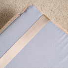 Graues Tatami-Lounger-Kissen mit beigem Band auf Teppichboden, Zenpaws Haustierbett.