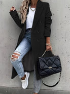 Eleganter schwarzer Mantel, kombiniert mit zerrissenen Jeans und weißem T-Shirt. Modische Handtasche und Sneakers runden den urbanen Look ab.