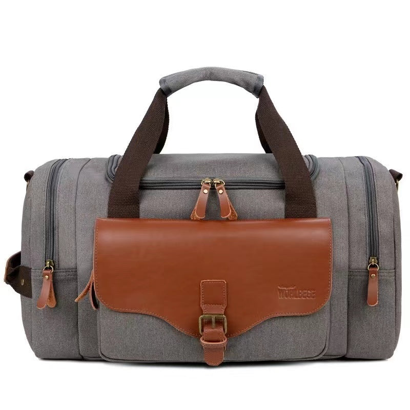 Graue Reisetasche aus Segeltuch mit braunen Lederakzenten, ideal für Wochenendausflüge.