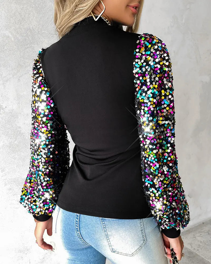 Schwarzes Oberteil mit bunten Paillettenärmeln, modisch und elegant. Perfekt für Partys und besondere Anlässe. Damenmode, Glitzer, Trend.