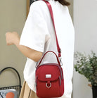 Frau mit roter Umhängetasche aus Leder, modisch, elegant, Damenaccessoire, Freizeitkleidung.