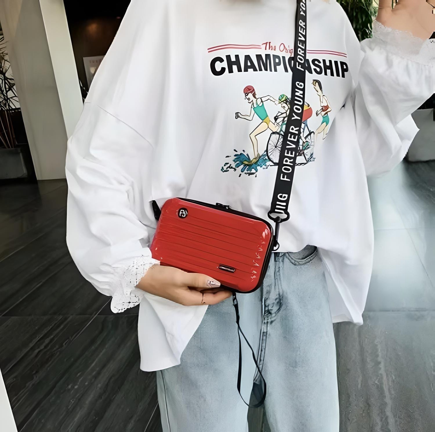 Frau mit roter Umhängetasche, lässiges Outfit, bedrucktes T-Shirt, Jeans, modisch, urban.