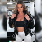 Schwarze Lackjacke, schwarze Crop-Top, weiße Hose, Frau vor Audi. Modetrend, urbaner Stil, stilvolle Damenbekleidung, Auto-Hintergrund.